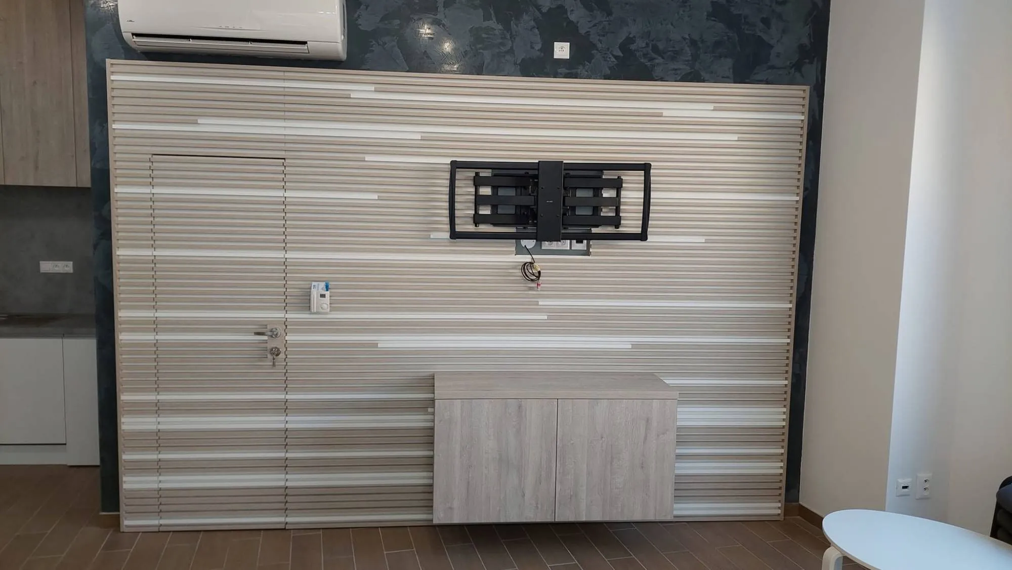 Lamelová stena za TV so skrytými dverami